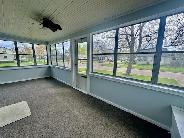 unfurnished sunroom featuring a ceiling fan