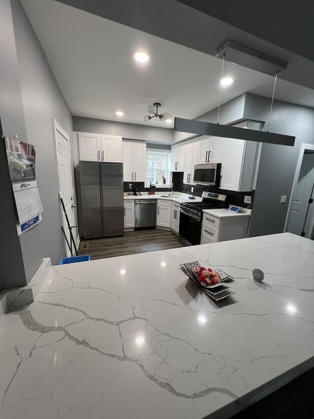 7435 S Indiana Ave, Chicago, IL 60619 - kitchen featuring a sink, white cabinets, appliances with stainless steel finishes, light stone countertops, and recessed lighting