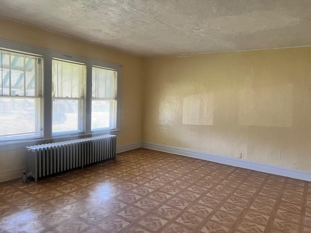 118 W 103rd Pl, Chicago, IL 60628 - spare room with radiator heating unit, a textured ceiling, baseboards, and light flooring