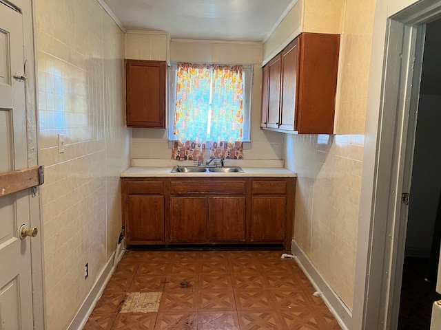 118 W 103rd Pl, Chicago, IL 60628 - kitchen with brown cabinetry, a sink, light countertops, and crown molding