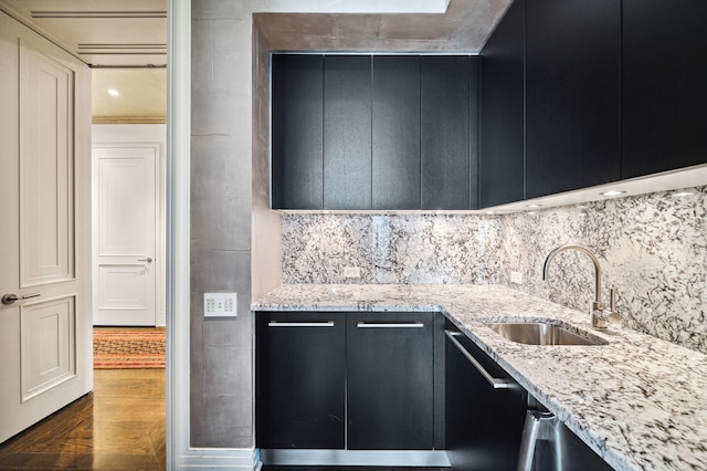 159 E Walton Pl Unit 34A, Chicago, IL 60611 - kitchen featuring backsplash, dark cabinetry, a sink, dark wood-type flooring, and light stone countertops