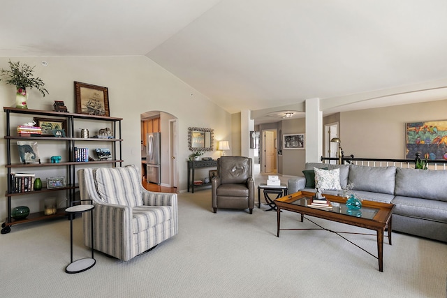 living room with arched walkways, vaulted ceiling, and light colored carpet