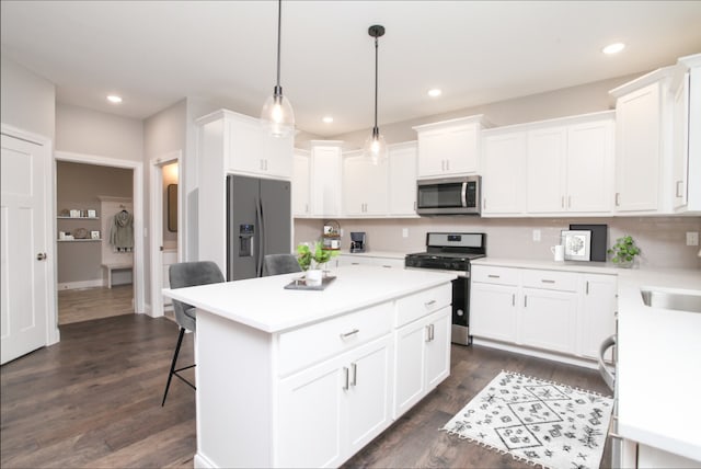 kitchen with a center island, stainless steel appliances, white cabinetry, and light countertops