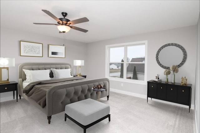 bedroom with light colored carpet, ceiling fan, and baseboards