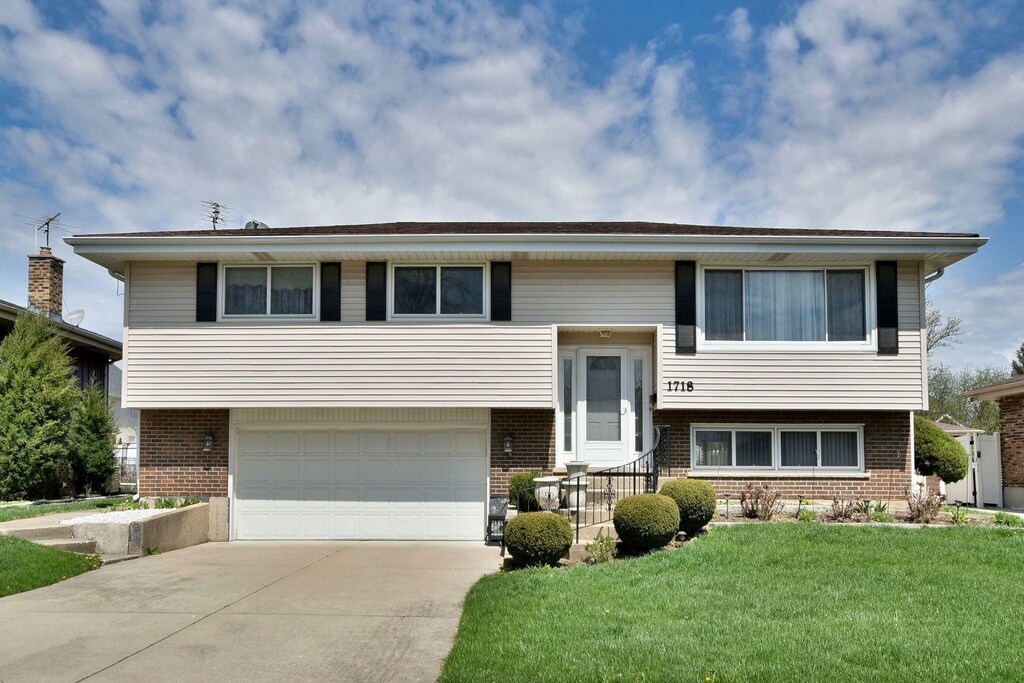 1718 W Woodland Ave, Addison, IL 60101 - bi-level home with brick siding, a front yard, and concrete driveway