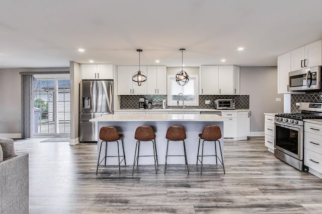 kitchen featuring a kitchen breakfast bar, stainless steel appliances, a kitchen island, and backsplash