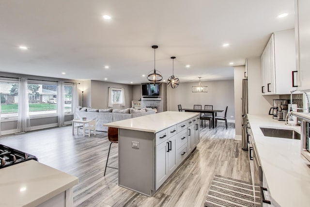 kitchen featuring recessed lighting, a kitchen island, light wood-style floors, and a kitchen bar