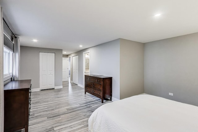 bedroom with baseboards, recessed lighting, and light wood-style flooring