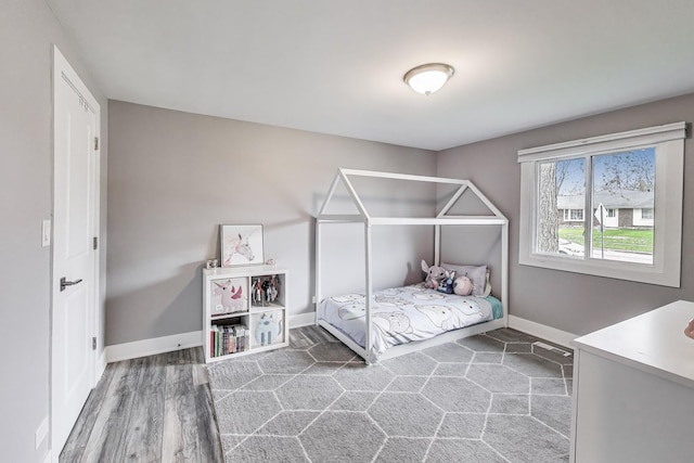 bedroom with wood finished floors and baseboards