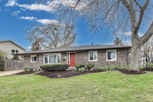 ranch-style home featuring fence, a front lawn, a chimney, and brick siding