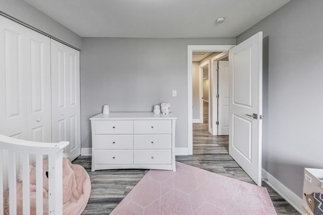 bedroom featuring baseboards, wood finished floors, and a closet