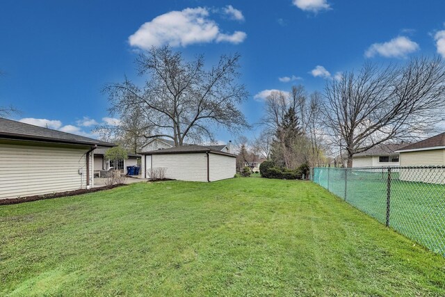 view of yard featuring fence and an outbuilding