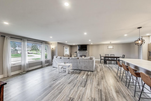 living area featuring recessed lighting, light wood finished floors, and baseboards
