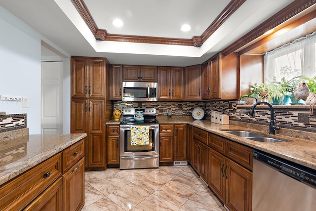 11138 Center Rd Unit E22, Palos Hills, IL 60465 - kitchen featuring appliances with stainless steel finishes, tasteful backsplash, a raised ceiling, light stone counters, and crown molding