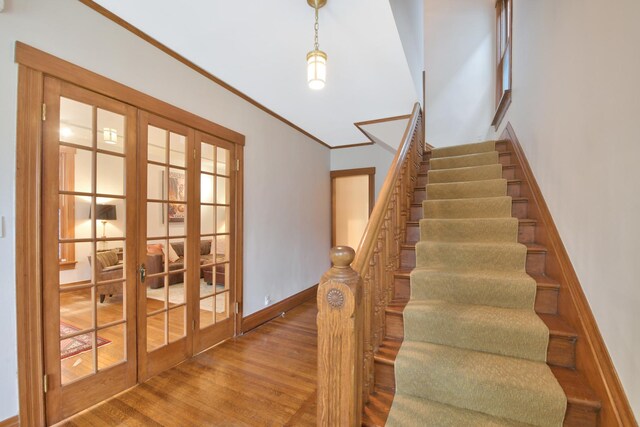 1726 Wesley Ave, Evanston, IL 60201 - stairway featuring baseboards, french doors, wood finished floors, and ornamental molding