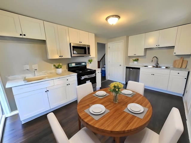 5133 W 64th St, Chicago, IL 60638 - kitchen featuring stainless steel appliances, light countertops, a sink, dark wood-type flooring, and white cabinetry
