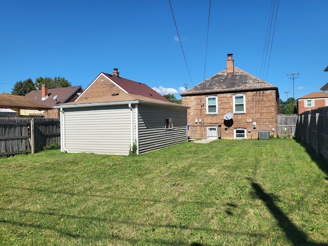 5133 W 64th St, Chicago, IL 60638 - back of property with a lawn, a fenced backyard, a chimney, and central AC