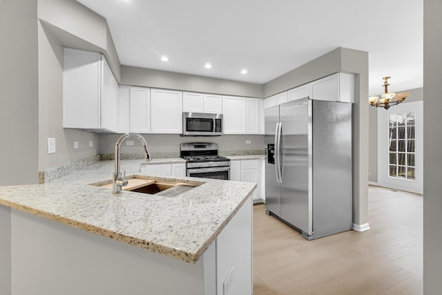 2073 Cambria Ct, Northbrook, IL 60062 - kitchen featuring light stone counters, a sink, stainless steel appliances, light wood-style flooring, and a peninsula