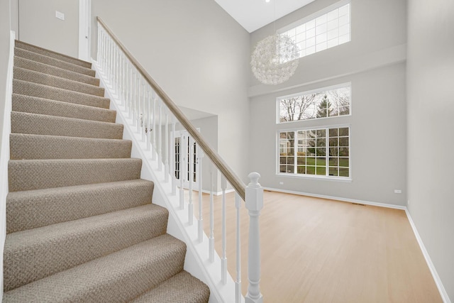 2073 Cambria Ct, Northbrook, IL 60062 - stairs with baseboards, wood finished floors, a towering ceiling, and a notable chandelier