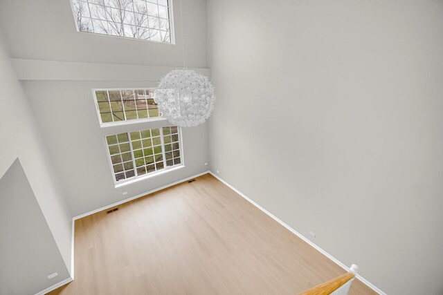 2073 Cambria Ct, Northbrook, IL 60062 - spare room with baseboards, wood finished floors, a high ceiling, and an inviting chandelier