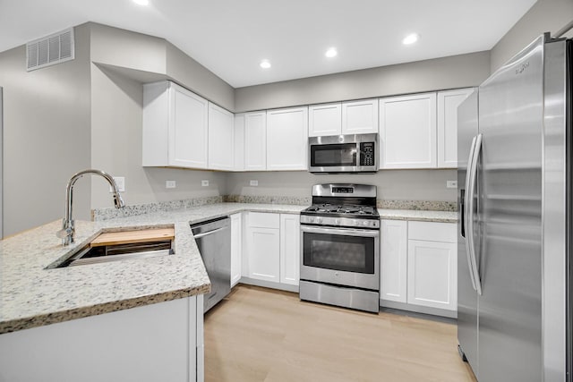 2073 Cambria Ct, Northbrook, IL 60062 - kitchen with visible vents, a sink, a peninsula, appliances with stainless steel finishes, and white cabinetry