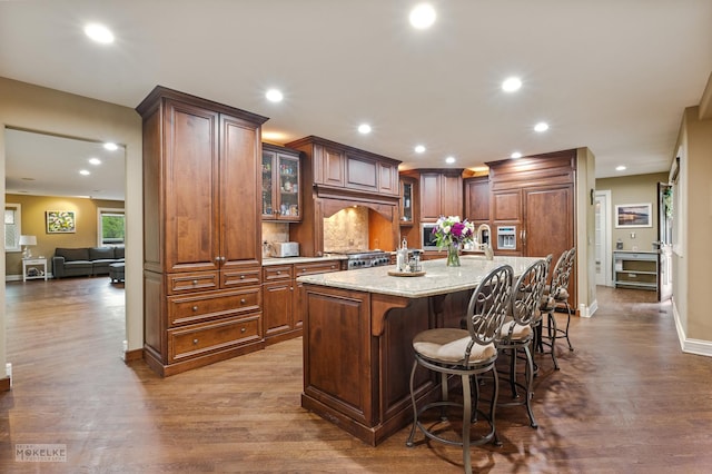 7S745 State Route 53rd Hwy, Naperville, IL 60540 - kitchen featuring glass insert cabinets, dark wood-type flooring, a kitchen island with sink, a breakfast bar, and recessed lighting