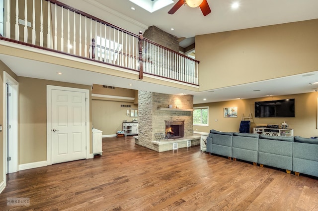 7S745 State Route 53rd Hwy, Naperville, IL 60540 - living area featuring a ceiling fan, a high ceiling, a fireplace, wood finished floors, and baseboards