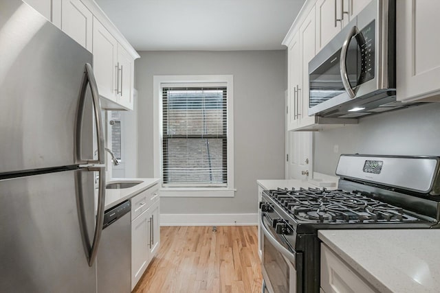 5415 S Dorchester Ave Unit 2B, Chicago, IL 60615 - kitchen featuring stainless steel appliances, baseboards, light wood-style flooring, a sink, and white cabinets