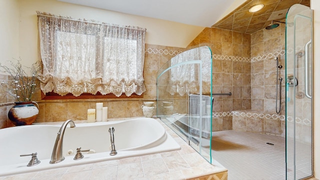 bathroom with tile walls, a bath, and a stall shower