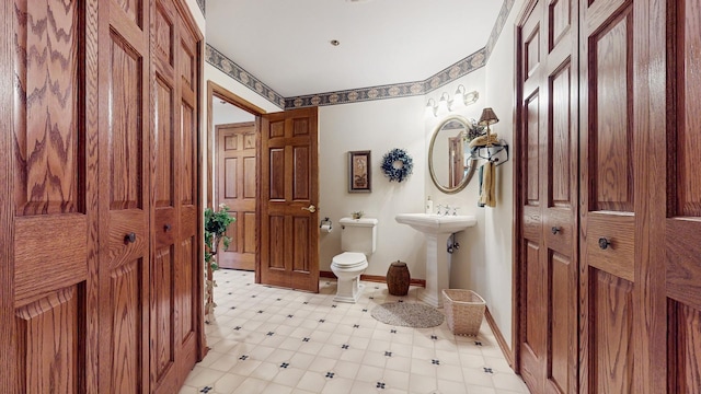bathroom featuring baseboards and toilet