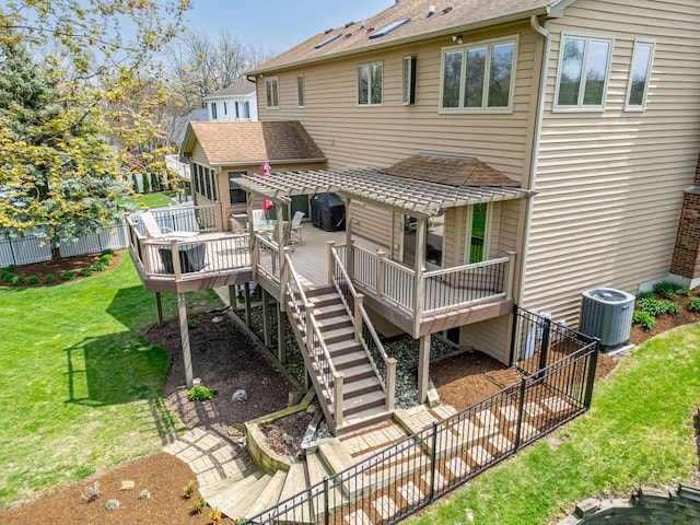 rear view of property featuring fence, a shingled roof, a wooden deck, central air condition unit, and a yard