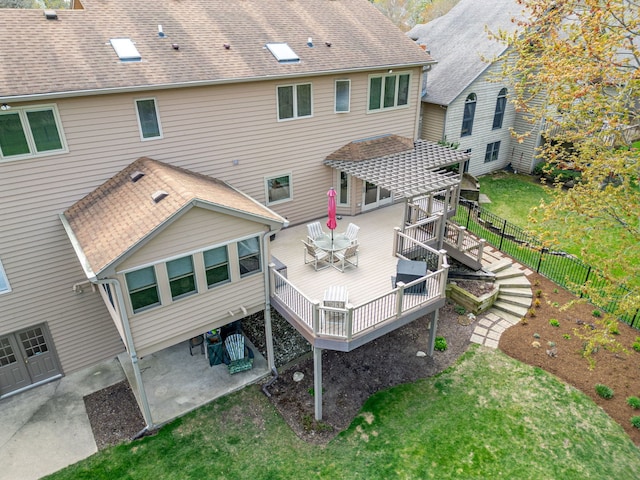 back of house with fence, a pergola, a deck, a lawn, and outdoor dining space