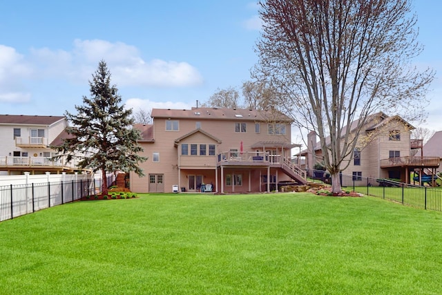 rear view of house featuring a lawn, a fenced backyard, a wooden deck, and stairway