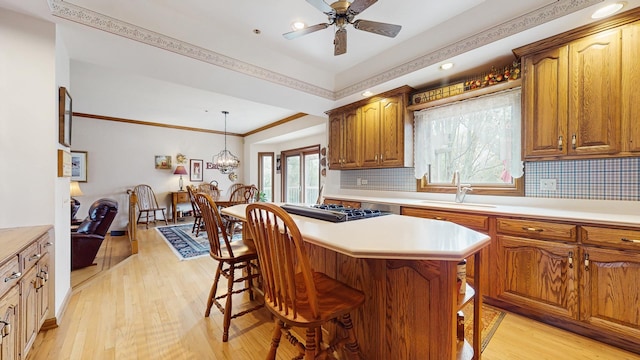 kitchen featuring light countertops, a breakfast bar, a sink, and light wood-style flooring