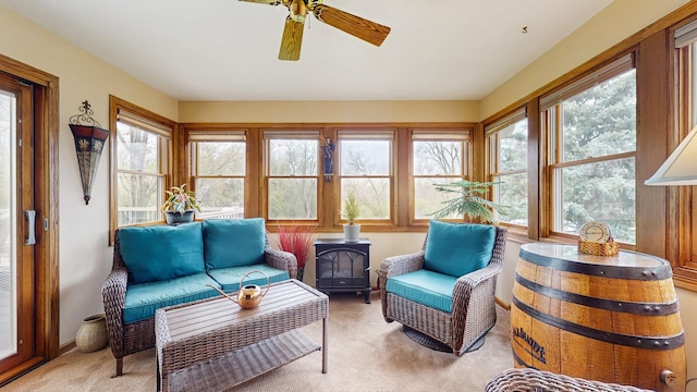 sunroom featuring carpet and a wood stove