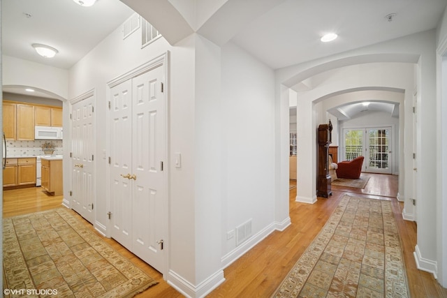 2365 Waukegan Rd Unit 2C, Northbrook, IL 60062 - hallway with visible vents, light wood-style floors, baseboards, and arched walkways