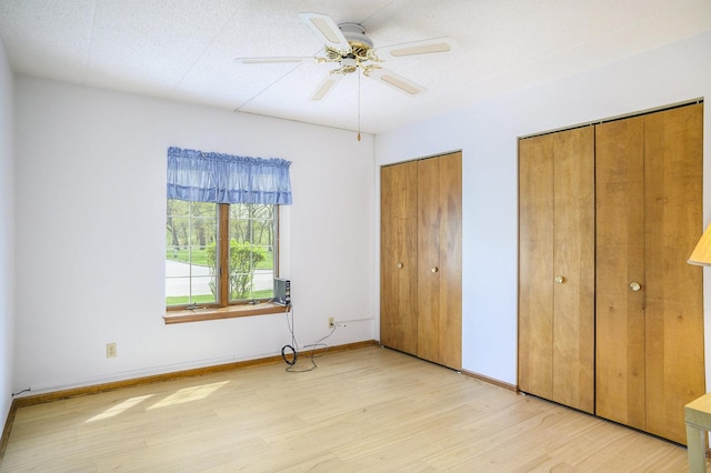 2608 186th St Unit 105, Lansing, IL 60438 - unfurnished bedroom featuring ceiling fan, light wood-style flooring, baseboards, and multiple closets