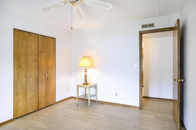 2608 186th St Unit 105, Lansing, IL 60438 - bedroom featuring a closet, light wood-type flooring, visible vents, a ceiling fan, and baseboards