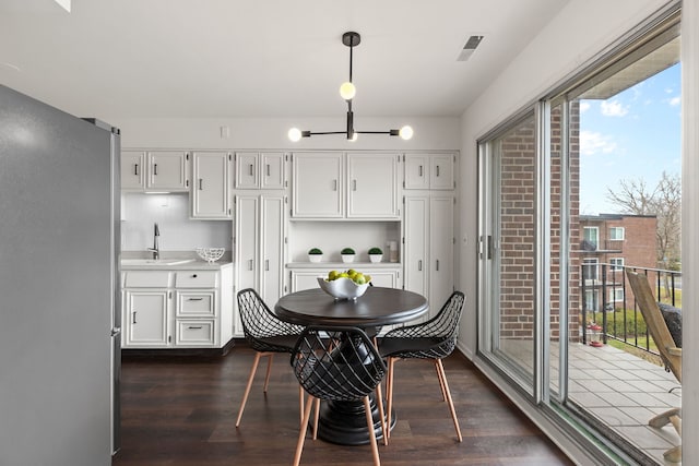 dining area with dark wood finished floors and visible vents