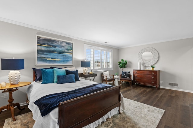 bedroom with baseboards, ornamental molding, wood finished floors, and visible vents