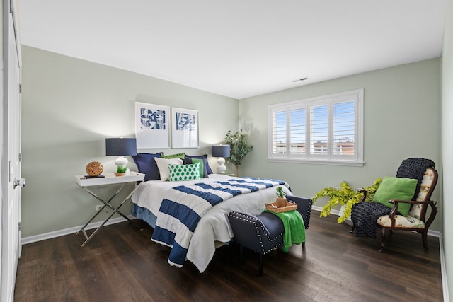 bedroom with visible vents, wood finished floors, and baseboards