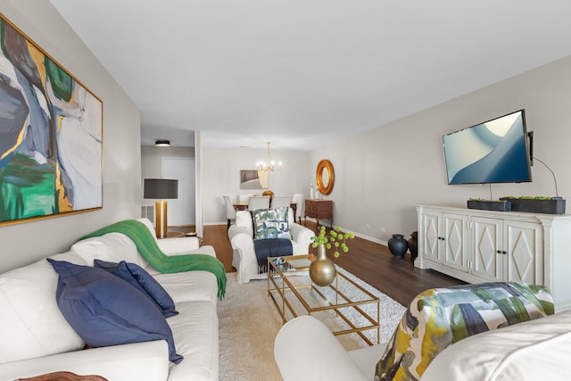 living area featuring baseboards, wood finished floors, and a chandelier