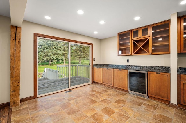 indoor dry bar featuring beverage cooler, light stone finish floors, recessed lighting, and baseboards