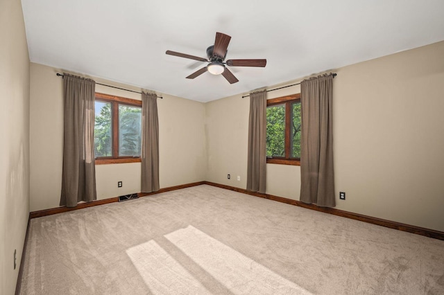 spare room with plenty of natural light, carpet, and a ceiling fan