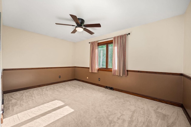spare room with carpet flooring, a ceiling fan, and baseboards