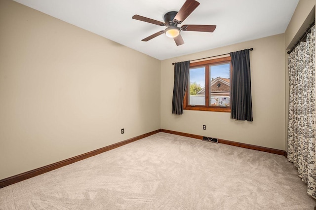 empty room with carpet, ceiling fan, and baseboards