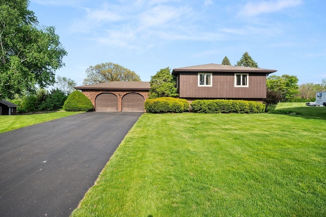 view of front facade featuring driveway, a front yard, and a garage