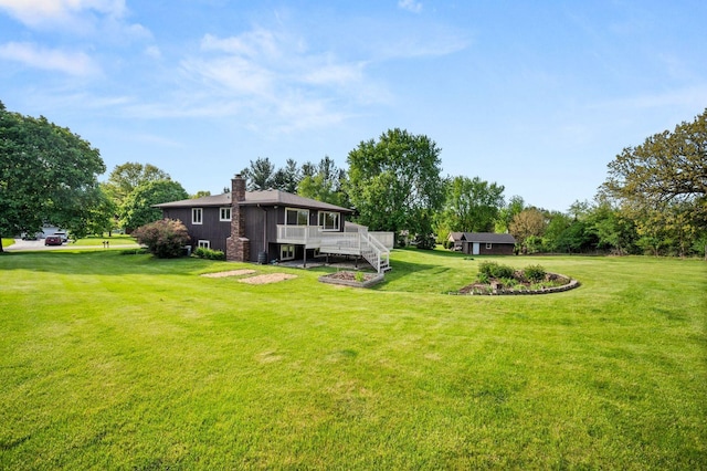 view of green lawn featuring a deck