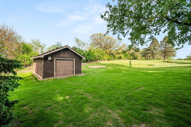 view of green lawn with an outbuilding and a garage