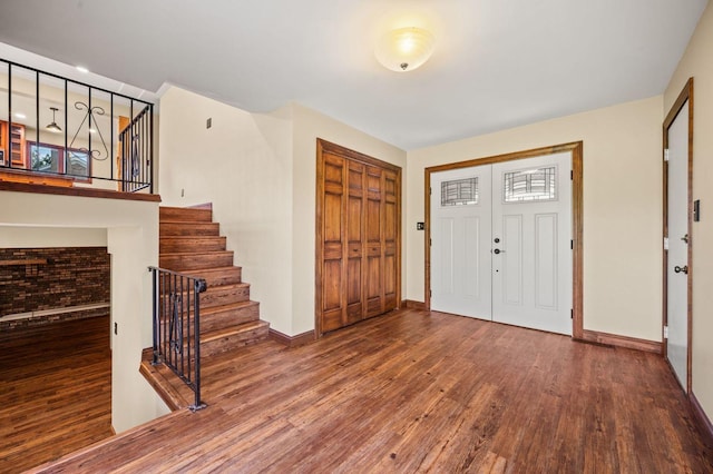 entryway featuring wood finished floors, stairs, and baseboards